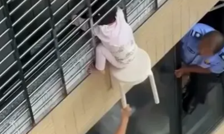 Video που κόβει την ανάσα: Τρίχρονη κρέμεται από τον 12ο με το κεφάλι σφηνωμένο στα κάγκελα στην Κίνα - Την κρατούσαν στον αέρα με σκαμπό