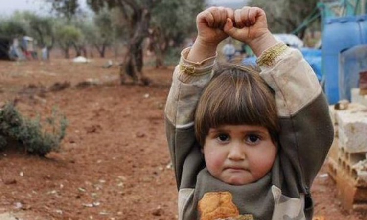 Θα ανατριχιάσετε: Αθώο παιδάκι στη Συρία μπερδεύει την κάμερα με όπλο και...σηκώνει τα χέρια ψηλά!
